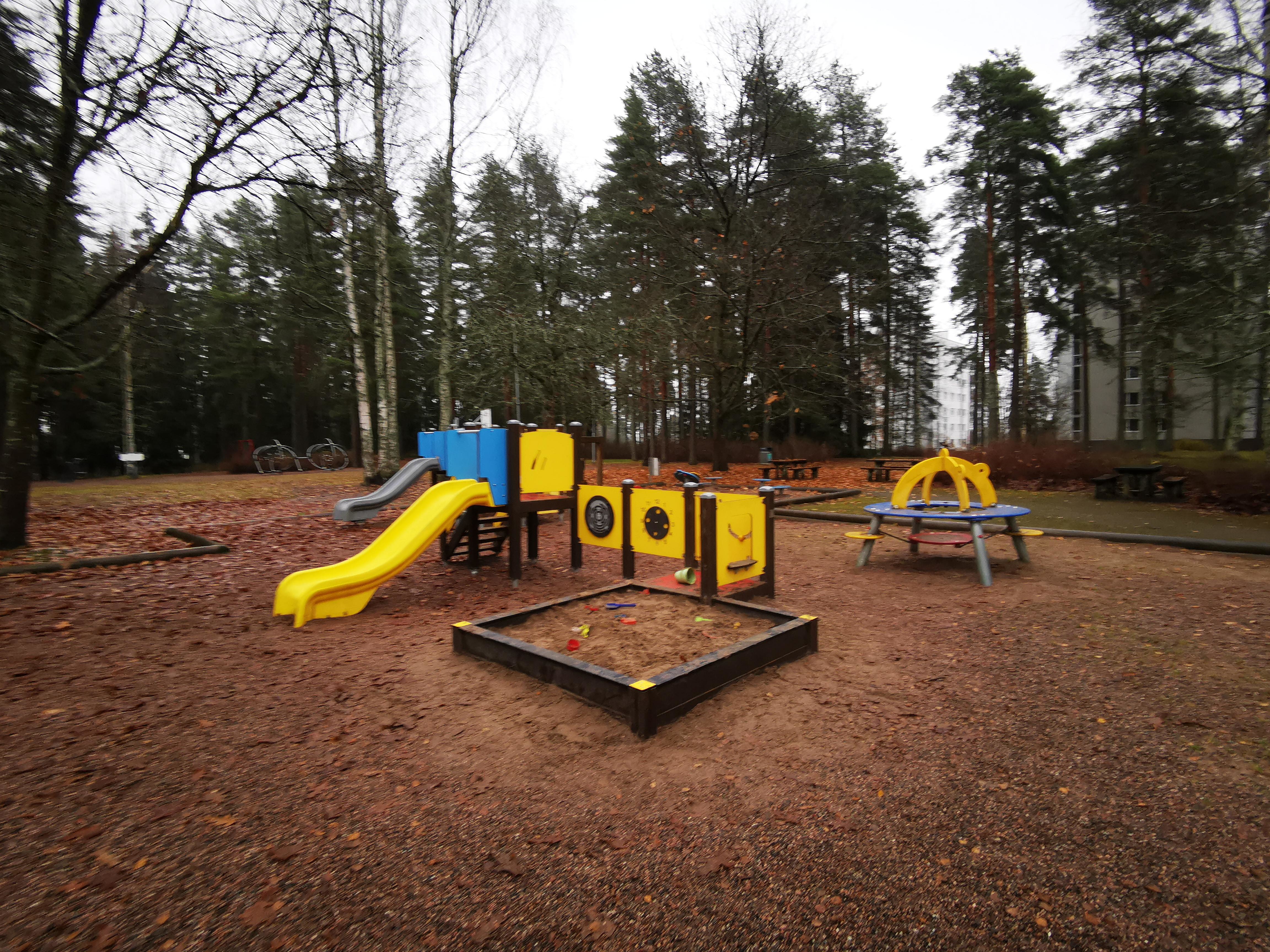 Kankolanpuiston leikkialueen kuvassa on hiekkalaatikko, liukumäki ja kiipeilyteline