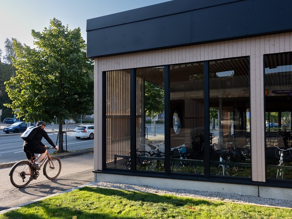 Pyöräilijä Uudenmaankadulla, uuden puuverhoillun pyöräkatoksen kohdalla